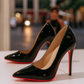Pair of womens black heels with pointed toe and high-shine finish