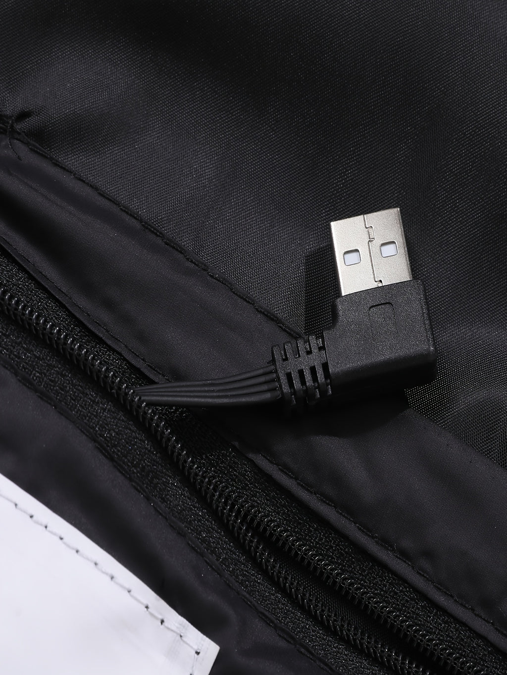 Mens heated jacket in Black, close-up of the USB lead in the inner pocket