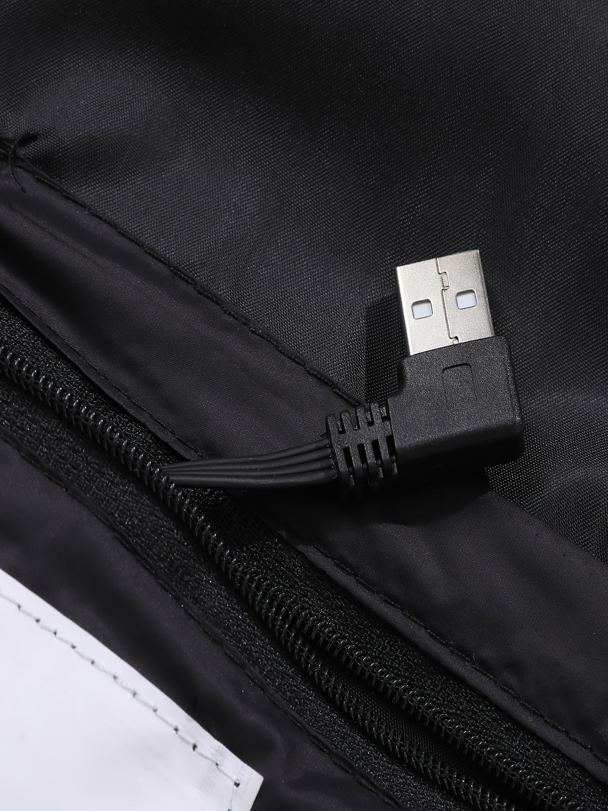 Mens heated jacket in Black, close-up of the USB lead in the inner pocket