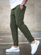 Mens casual pants in Olive, tapered leg with drawstring waist, worn with white sneakers