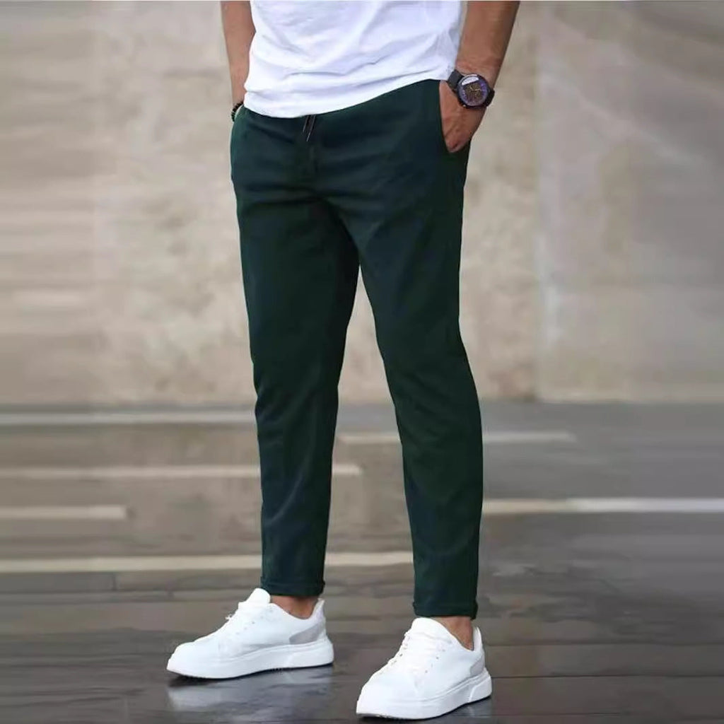 Mens casual pants in Green, tapered leg with drawstring waist, worn with white sneakers