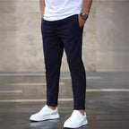 Mens casual pants in Navy, tapered leg with drawstring waist, worn with white sneakers