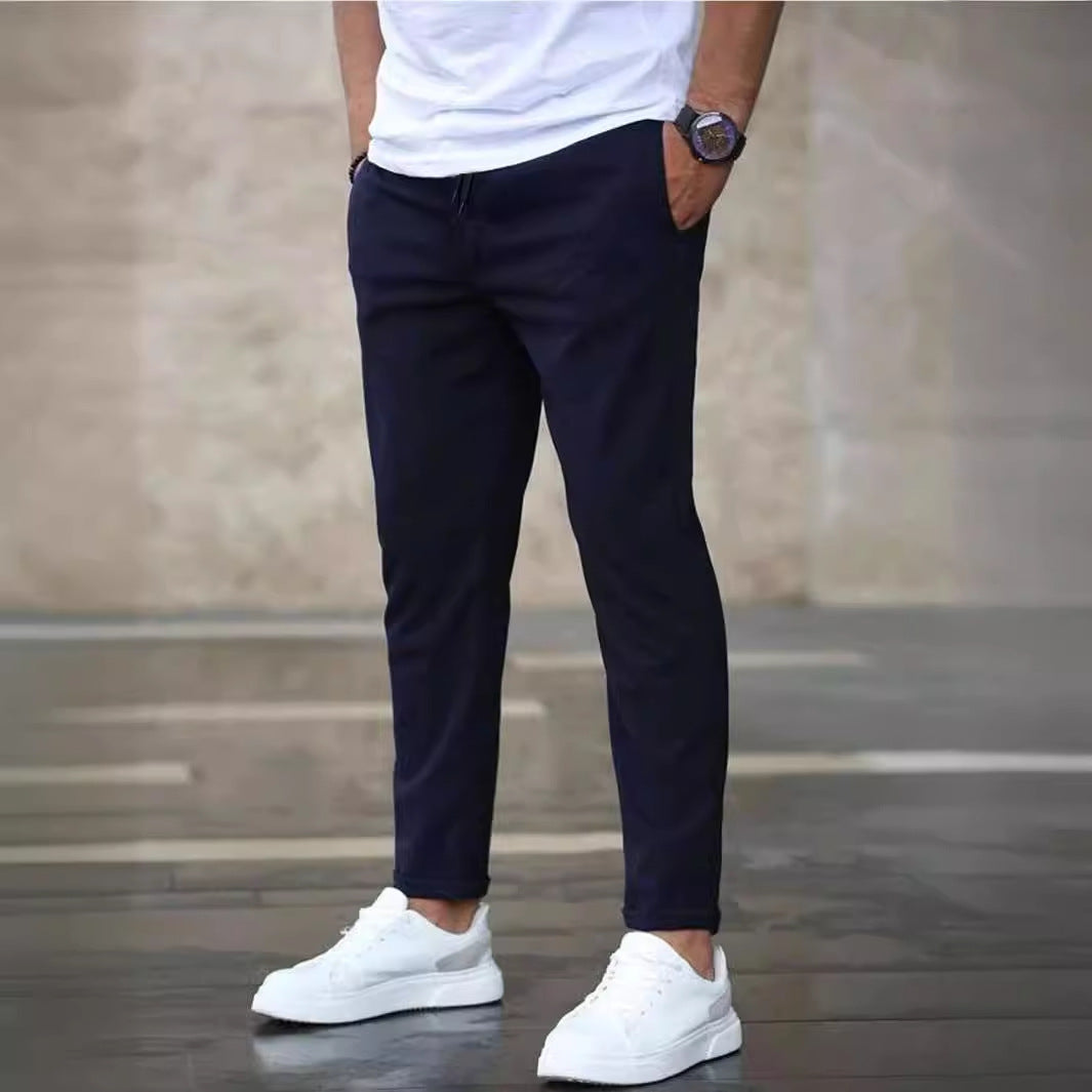 Mens casual pants in Navy, tapered leg with drawstring waist, worn with white sneakers