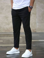 Mens casual pants in Black, tapered leg with drawstring waist, worn with white sneakers
