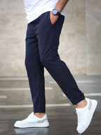 Mens casual pants in Navy, tapered leg with drawstring waist, worn with white sneakers