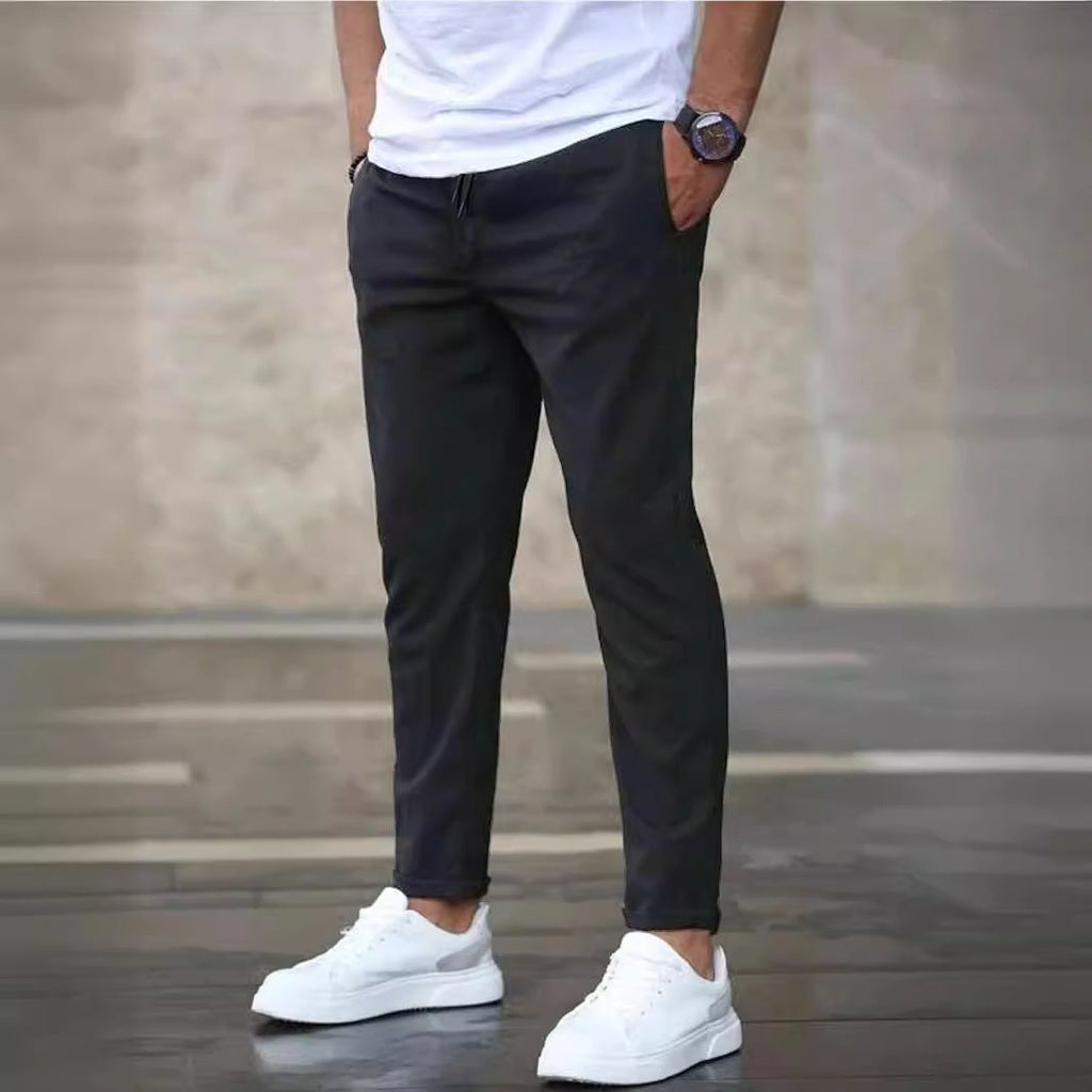 Mens casual pants in Charcoal, tapered leg with drawstring waist, worn with white sneakers
