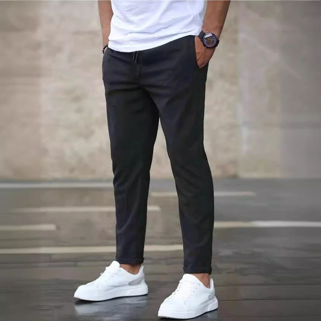 Mens casual pants in Charcoal, tapered leg with drawstring waist, worn with white sneakers