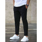 Mens casual pants in Black, tapered leg with drawstring waist, worn with white sneakers
