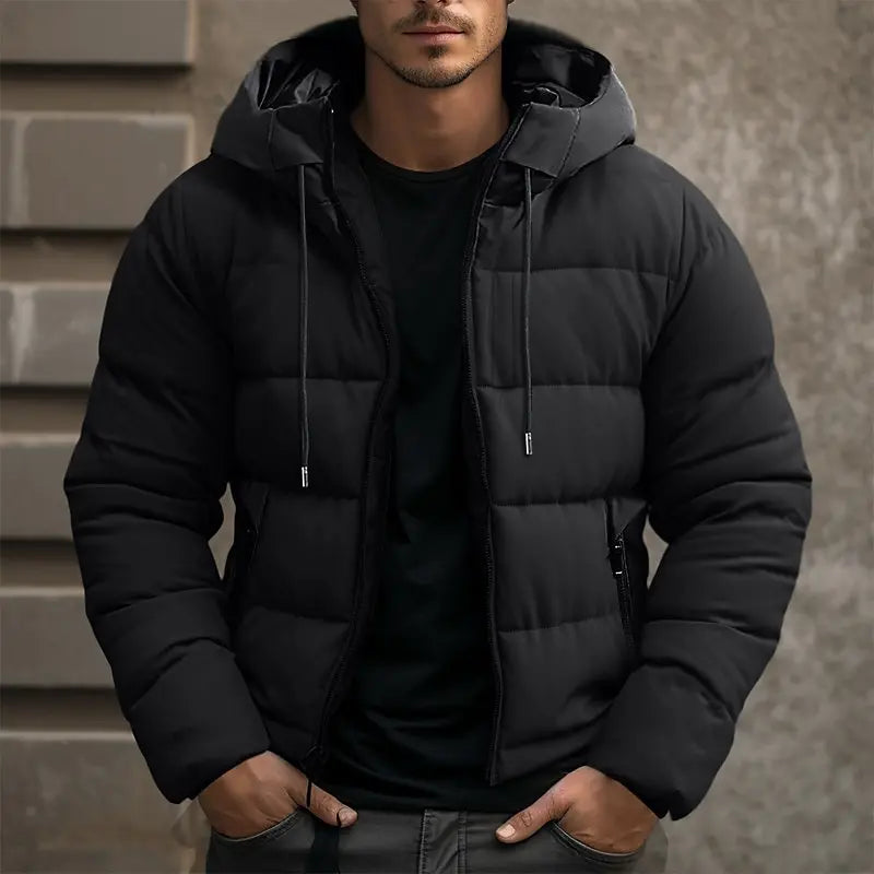 Mens puffer jacket in Black with drawstring hood, worn over a black tee