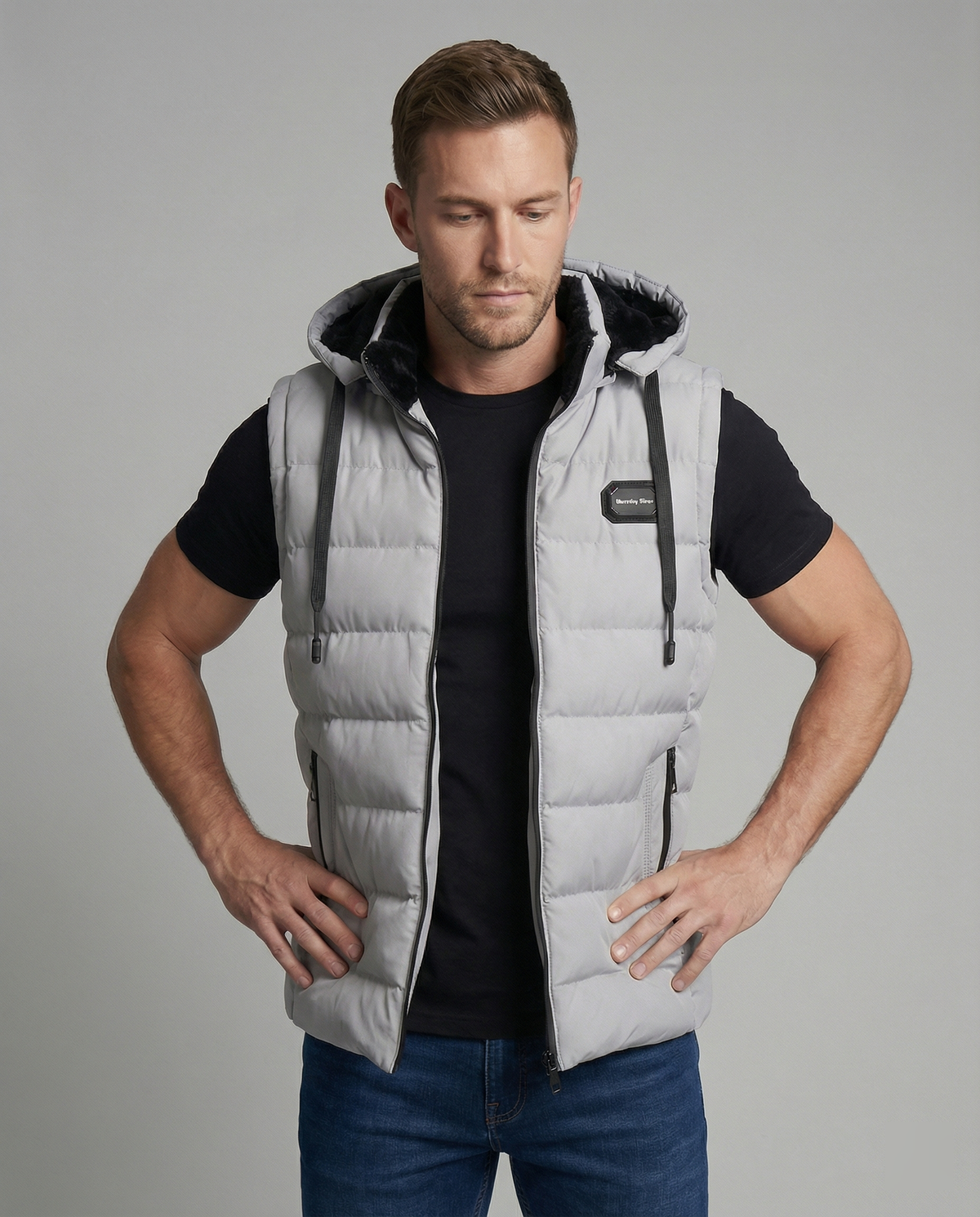 Mens puffer vest with hood in Gray, worn over a black tee, front view