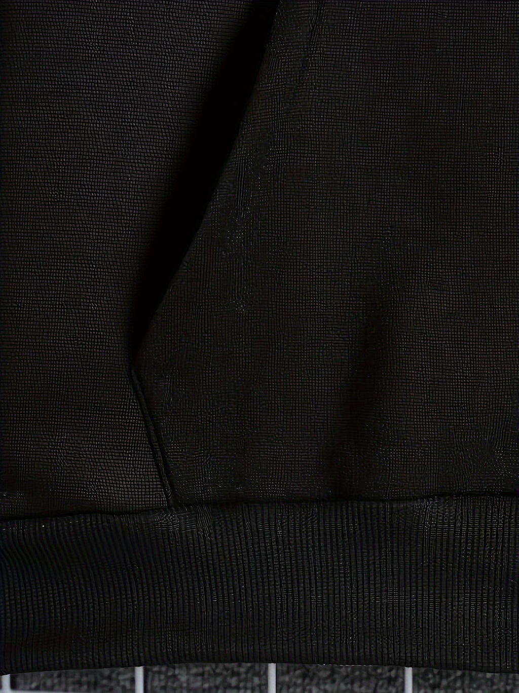 Mens zip up hoodie, close-up of the black kangaroo pocket and ribbed hem