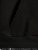 Mens zip up hoodie, close-up of the black kangaroo pocket and ribbed hem