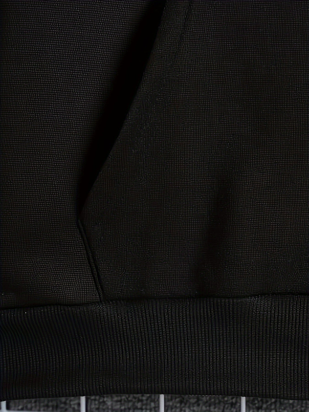 Mens zip up hoodie, close-up of the black kangaroo pocket and ribbed hem