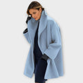 Womens wool coat with shawl collar in Blue, swing cut, worn open over dark knitwear