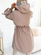 Womens waterproof jacket from the back with hood up and gathered waist